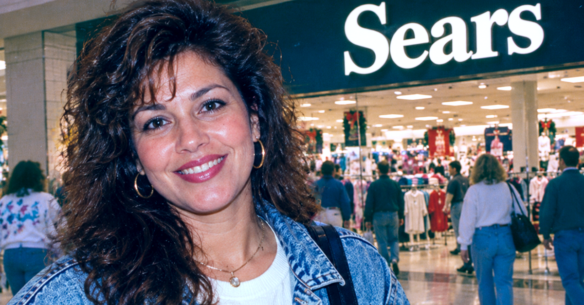 1990s mom with curly hair and jean jacket in front of a Sears in a mall