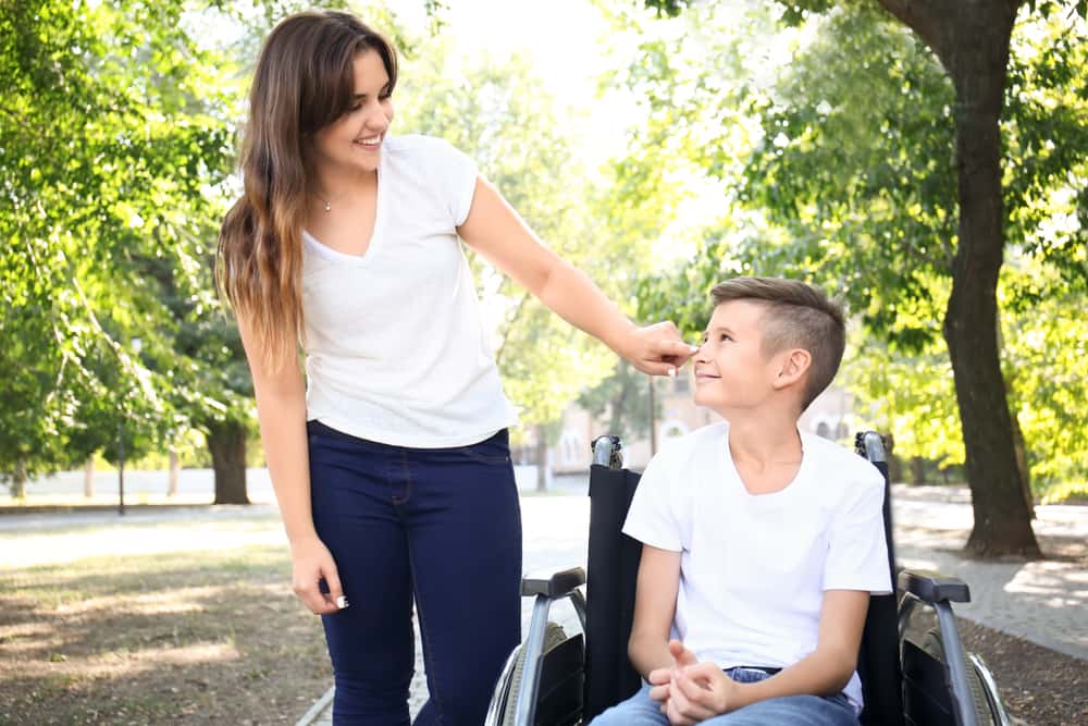 Teenage,Boy,In,Wheelchair,With,His,Mother,Outdoors