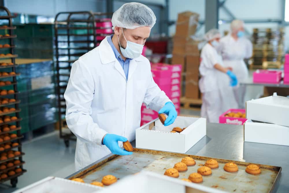 Confectionery,Factory,Worker,In,White,Coat,Collecting,Freshly,Baked,Pastry