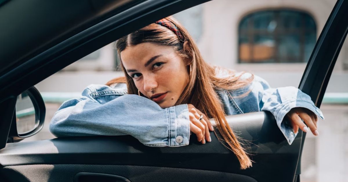 A woman leaning out of a car window.