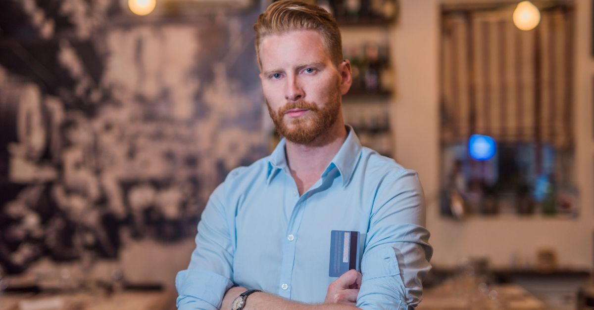 898256822-Portrait of a young man with a credit card in the bar