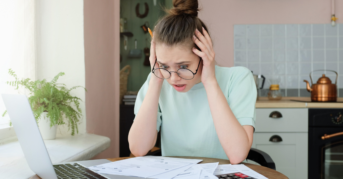 Young anxious worrying woman looks desperately to bills