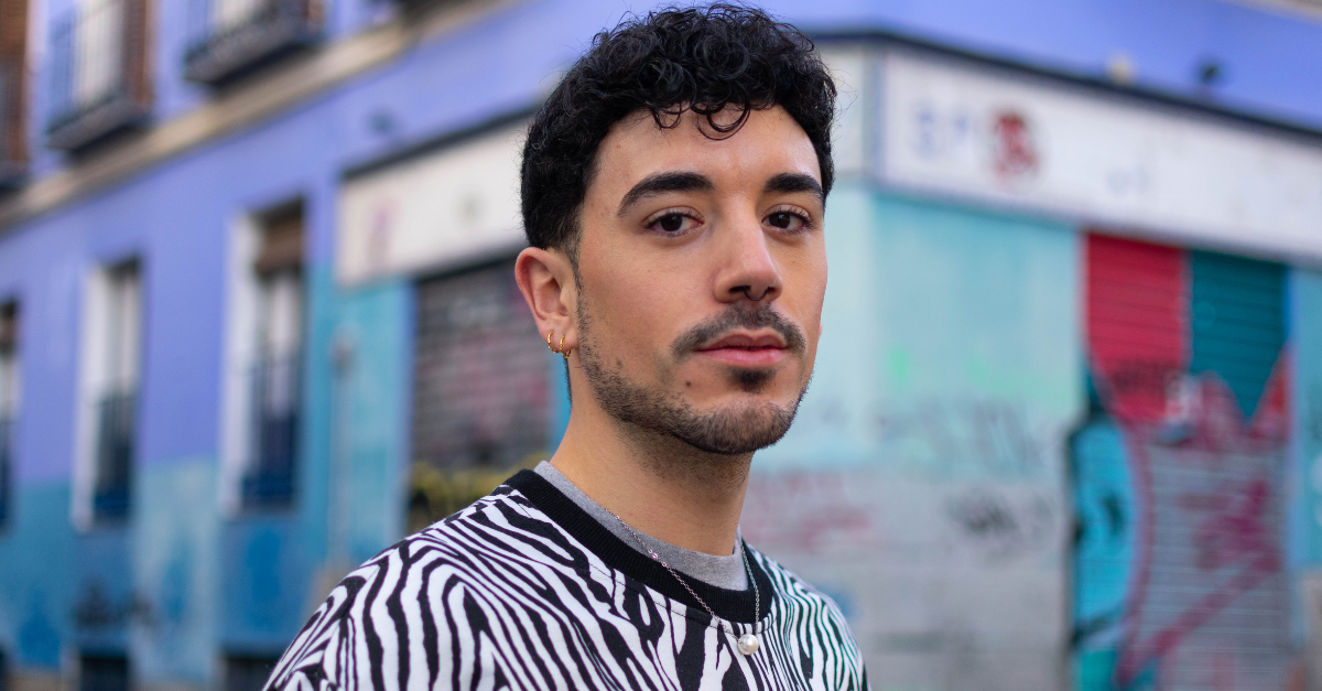 Young hispanic man with serious expression standing at the city