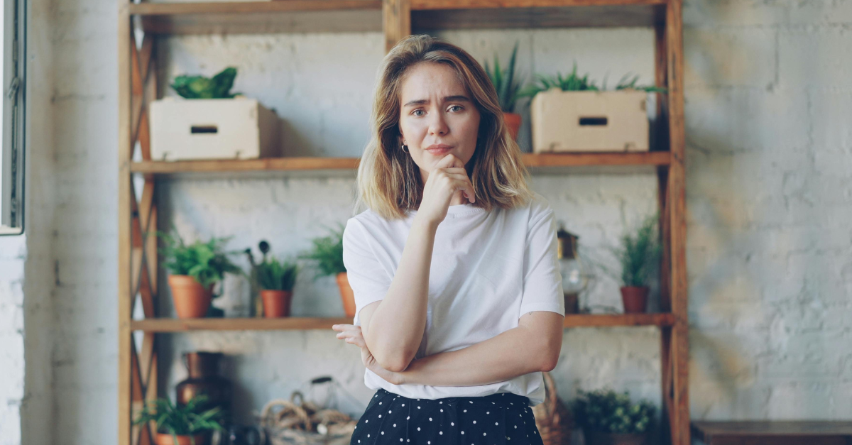 pensive-woman-posing-in-plant-filled-room