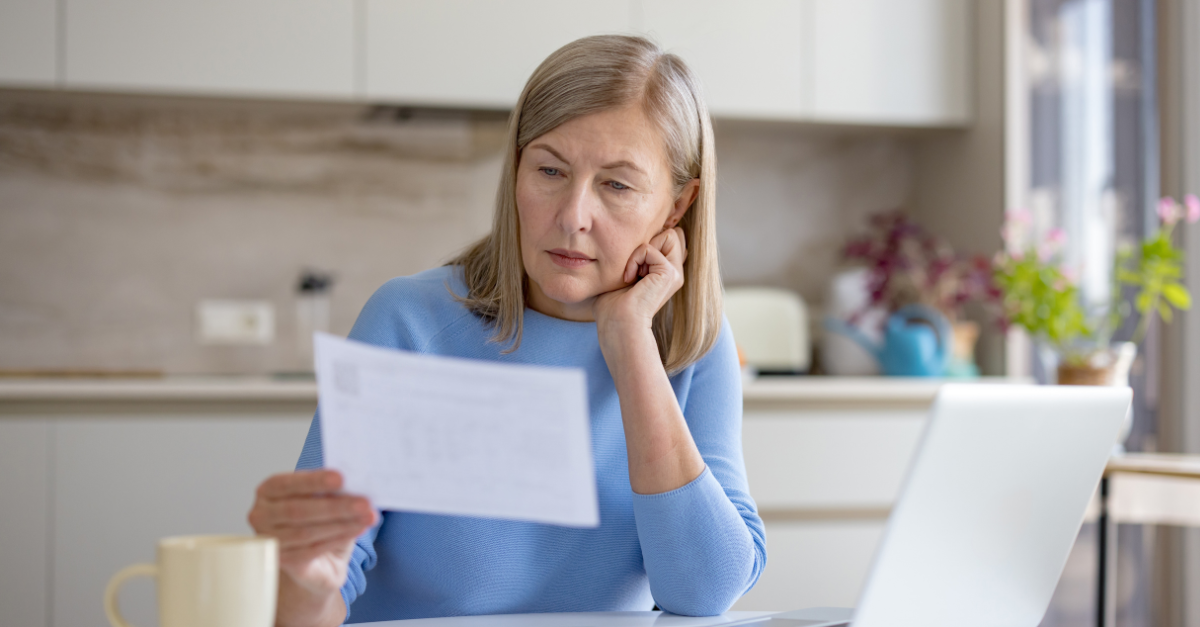 Mature woman analyzing financial documents and bills