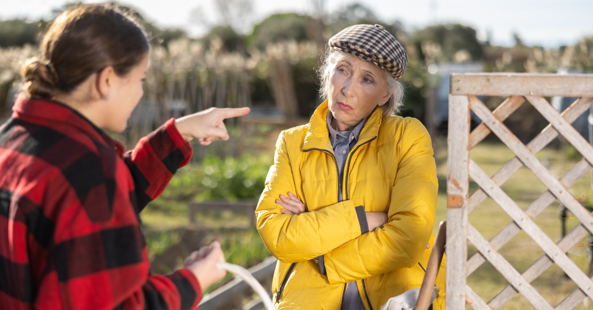 Two upset young and old female neighbors disagree