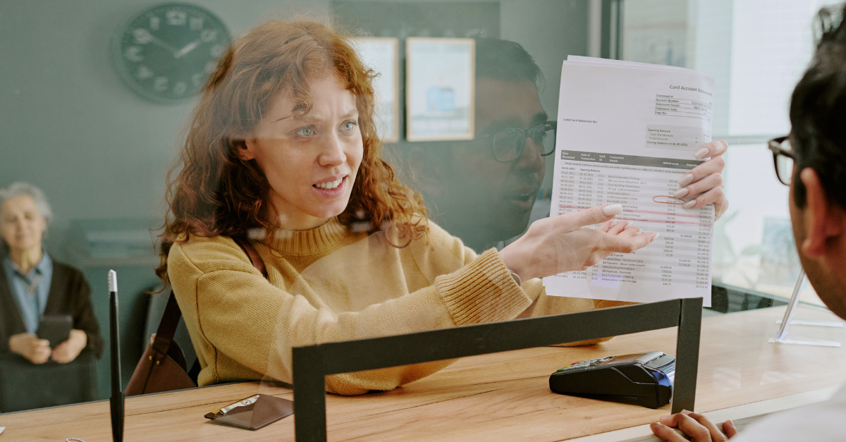 Scene showing woman discussing documents with bank employee