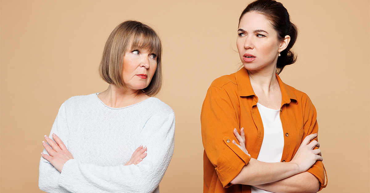 Elder sad mad offended parent mom 50s years old with young adult daughter two women together wear casual clothes hold hands crossed folded isolated on plain light beige background. Family day concept