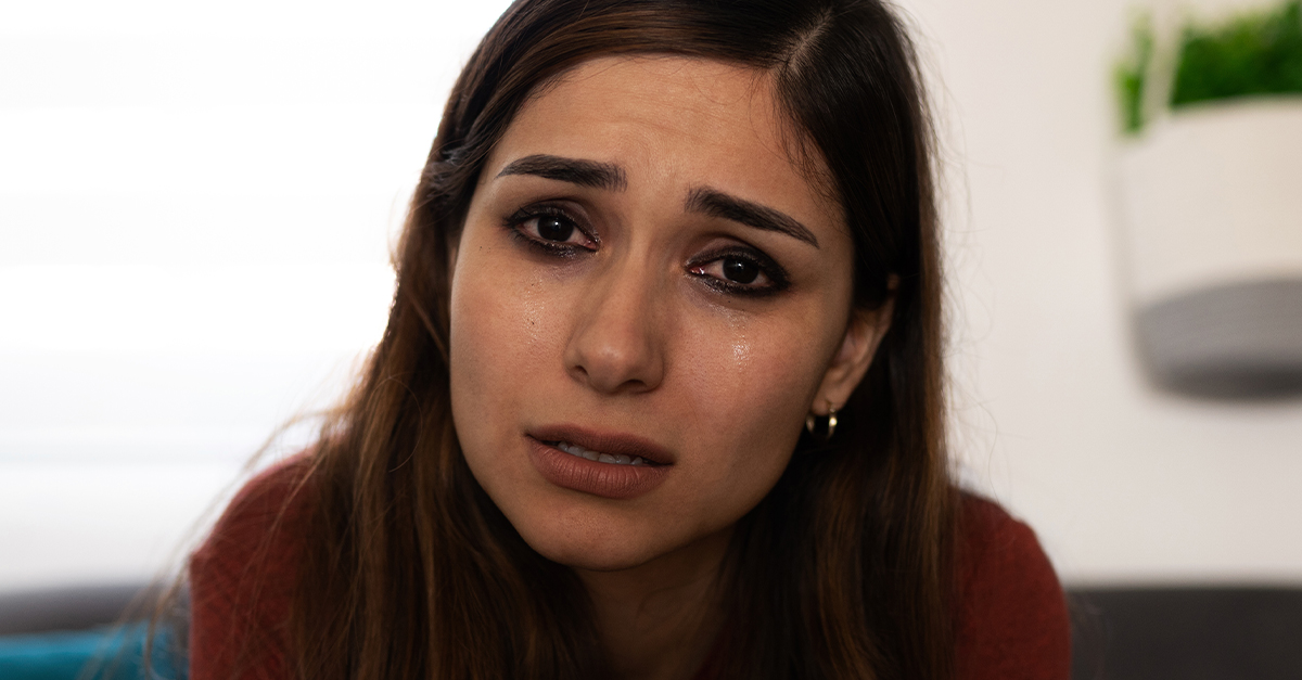 Crying woman, making eye contact with the viewer.