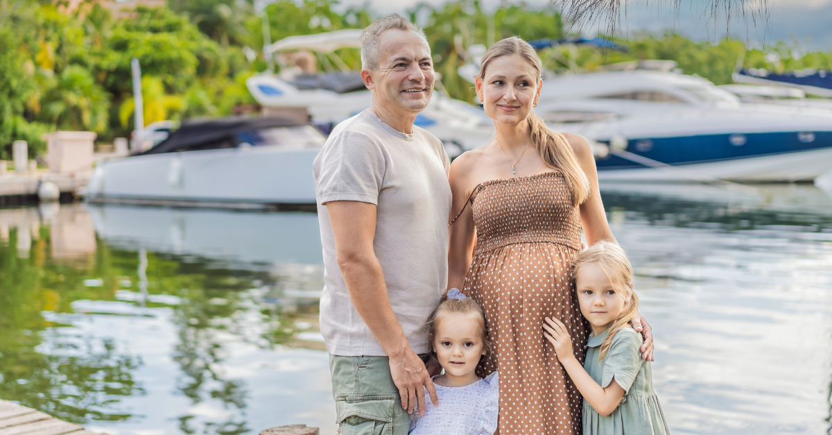 A happy, mature couple over 40 with their two daughters enjoying a leisurely walk on the waterfront