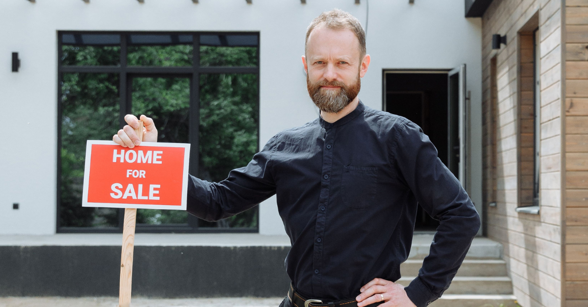 a-man-in-black-long-sleeves-holding-a-signage