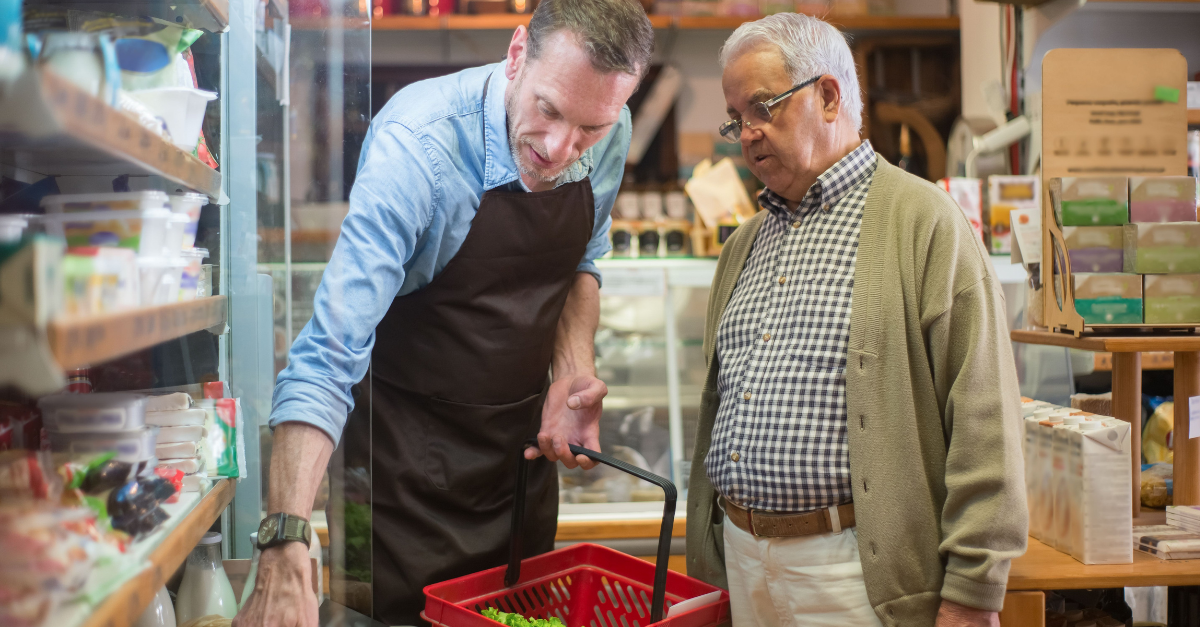man-wearing-an-apron-helping-a-elderly-man