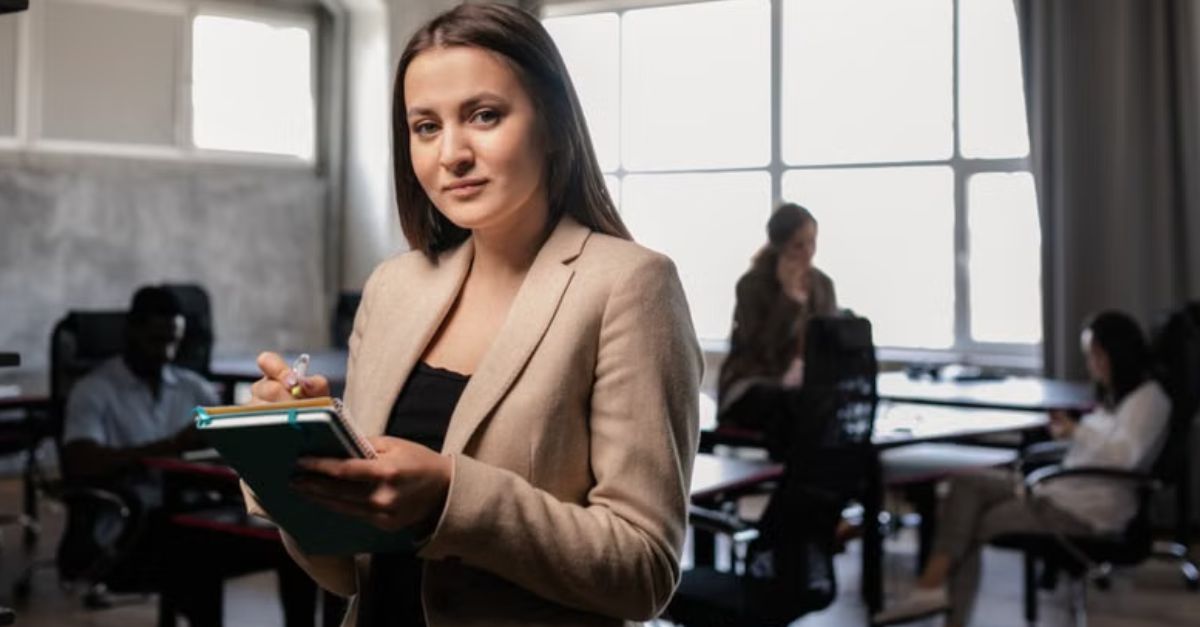 Confident businesswoman holding a notebook in a stylish, modern office.