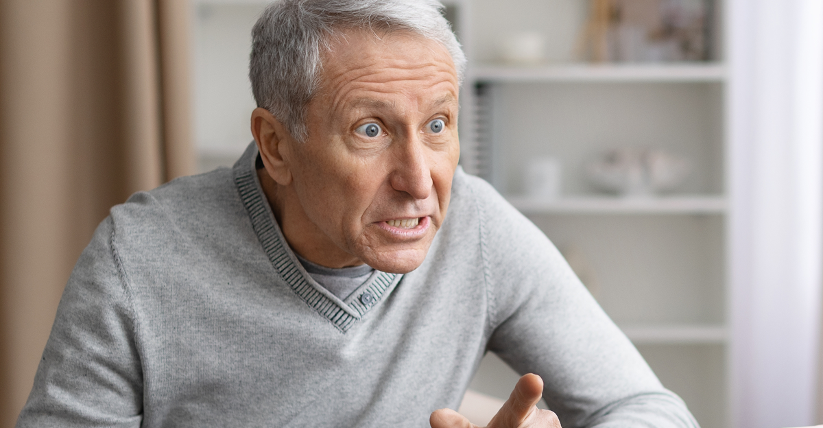 Senior couple arguing at home during emotional discussion, expressing frustration