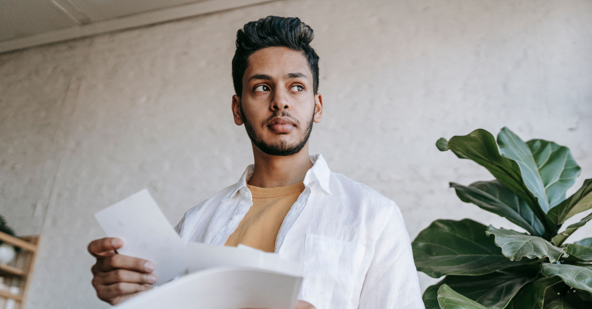 man-holding-printed-photos-in-living-room